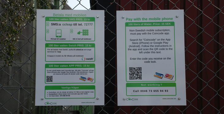 Bild på instruktionstavlorna för betalning som sitter på staketet vid dricksvattenstationen