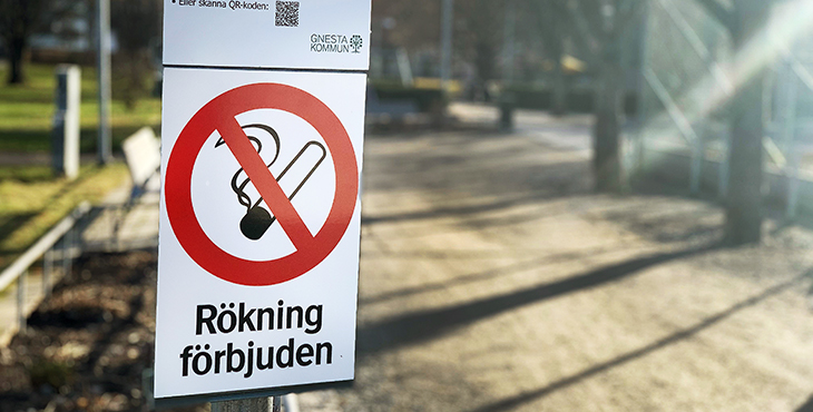 skylt med symbol för rökning förbjuden i lekpark