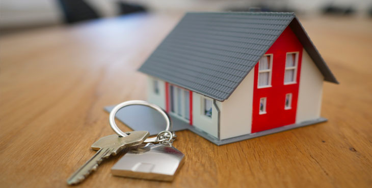 Nyckel med en nyckelring som ser ut som ett hus
