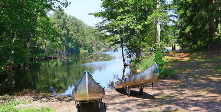 Två metallfärgade kanoter upptagna ur vattnet. 