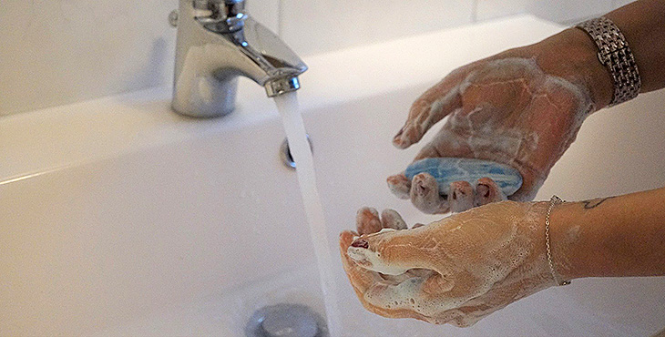 Person som tvättar händerna med tvål och vatten