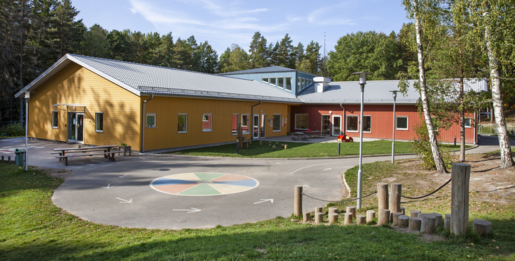 Förskolan Fågeldansen i Gnesta med en kulle av gräs i förgrunden