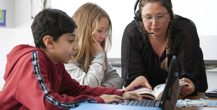 Lärare och två elever framför datorskärmar i ett klassrum på Frejaskolan