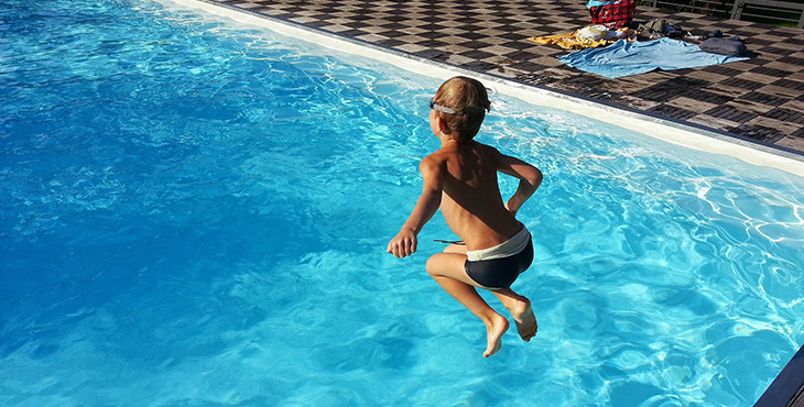 barn som hoppar i en pool